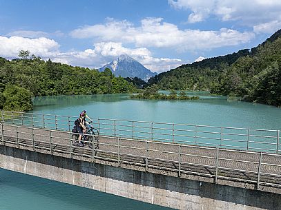 Cyclists on the bridge on the lake of Verzegnis