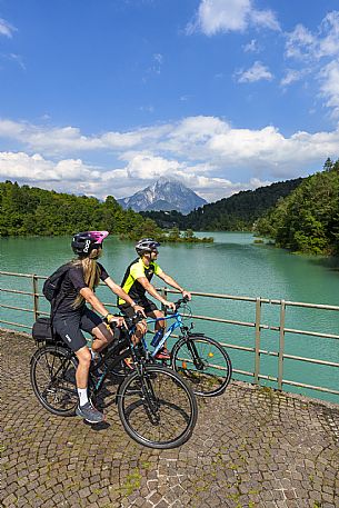 Cyclists on the bridge on the lake of Verzegnis