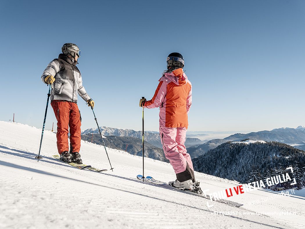 Alpine ski wit two skiers. Di Prampero slope on Lussari Mount.