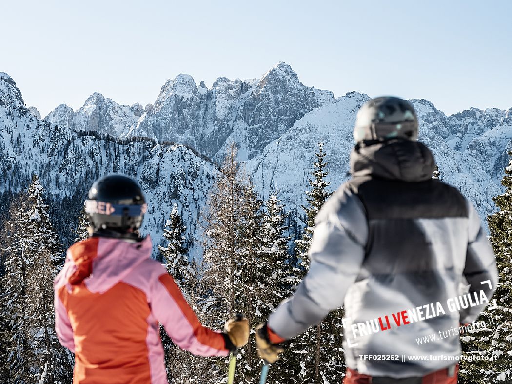 Alpine ski wit two skiers. Di Prampero slope on Lussari Mount.