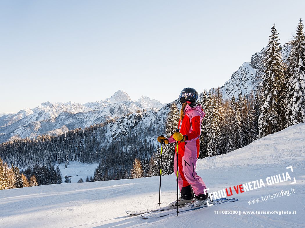 Alpine ski with joung skier woman. Di Prampero slope on Lussari Mount.
