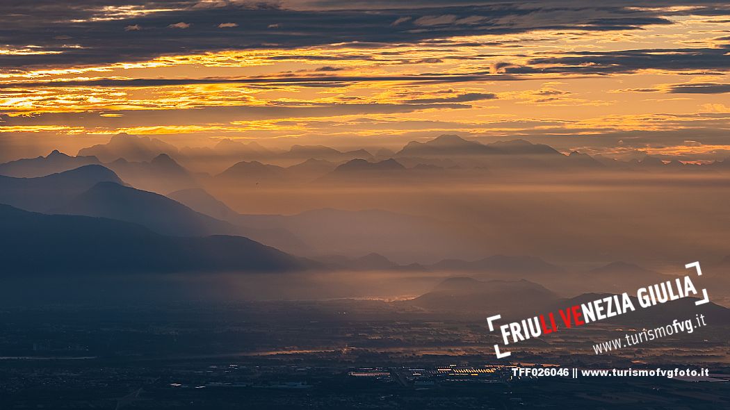 Sunrise on the Friulian plain from Piancavallo (Castaldia). On the background the mountain range of Carnia and Julian Alps 