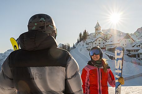 Alpine ski wit two skiers. Di Prampero slope on Lussari Mount.