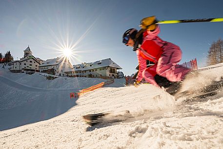 Alpine ski action with a skier woman  at Di Prampero slope on Lussari Mount.