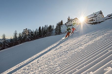 Alpine ski action wit two skiers. Di Prampero slope on Lussari Mount.