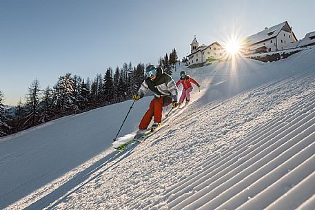 Alpine ski action wit two skiers. Di Prampero slope on Lussari Mount.