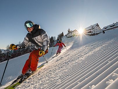 Alpine ski action wit two skiers. Di Prampero slope on Lussari Mount.