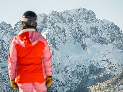 Alpine ski with joung skier woman. Di Prampero slope on Lussari Mount.