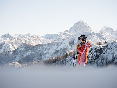 Alpine ski with joung skier woman. Di Prampero slope on Lussari Mount.