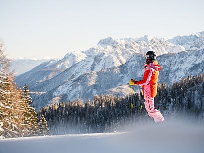 Alpine ski with joung skier woman. Di Prampero slope on Lussari Mount.