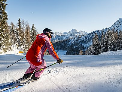 Alpine ski action with joung skier woman. Florianca slope on Lussari Mount.