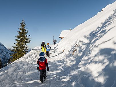 Child skiers walking on Lussari Mount