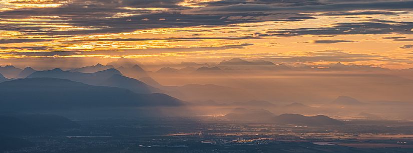 Sunrise on the Friulian plain from Piancavallo (Castaldia). On the background the mountain range of Carnia and Julian Alps 