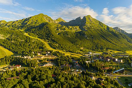 The town of Piancavallo seen from above. In the background the Cima del Cavallo and on the right the Friulian Dolomites and Valcellina