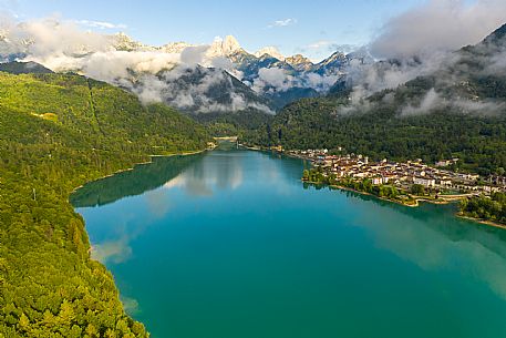 Barcis and its enchanting lake, on a sunny summer morning. In the background the peaks of the Cavallo group and the Friulian Dolomites.