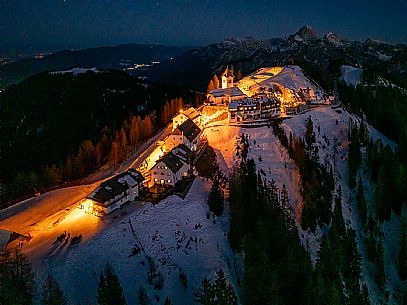 Night view of Monte Santo di Lussari, Italy, with illuminated buildings and a snowy slope. The Di Prampero slope in Camporosso welcomed the new year with the longest torchlight procession in the entire Alpine arc. Night view of Monte Santo di Lussari, Italy, with illuminated buildings and a snowy slope. The Di Prampero slope in Camporosso welcomed the new year with the longest torchlight procession in the entire Alpine arc.