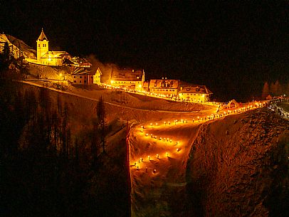 Night view of Monte Santo di Lussari, Italy, with illuminated buildings and a snowy slope. The Di Prampero slope in Camporosso welcomed the new year with the longest torchlight procession in the entire Alpine arc. Night view of Monte Santo di Lussari, Italy, with illuminated buildings and a snowy slope. The Di Prampero slope in Camporosso welcomed the new year with the longest torchlight procession in the entire Alpine arc.