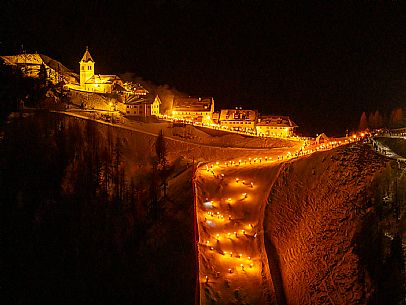 Night view of Monte Santo di Lussari, Italy, with illuminated buildings and a snowy slope. The Di Prampero slope in Camporosso welcomed the new year with the longest torchlight procession in the entire Alpine arc. Night view of Monte Santo di Lussari, Italy, with illuminated buildings and a snowy slope. The Di Prampero slope in Camporosso welcomed the new year with the longest torchlight procession in the entire Alpine arc.