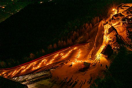 Night view of Monte Santo di Lussari, Italy, with illuminated buildings and a snowy slope. The Di Prampero slope in Camporosso welcomed the new year with the longest torchlight procession in the entire Alpine arc. Night view of Monte Santo di Lussari, Italy, with illuminated buildings and a snowy slope. The Di Prampero slope in Camporosso welcomed the new year with the longest torchlight procession in the entire Alpine arc.