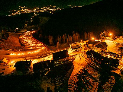 Night view of Monte Santo di Lussari, Italy, with illuminated buildings and a snowy slope. The Di Prampero slope in Camporosso welcomed the new year with the longest torchlight procession in the entire Alpine arc. Night view of Monte Santo di Lussari, Italy, with illuminated buildings and a snowy slope. The Di Prampero slope in Camporosso welcomed the new year with the longest torchlight procession in the entire Alpine arc.