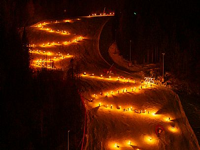 Night view of Monte Santo di Lussari, Italy, with illuminated buildings and a snowy slope. The Di Prampero slope in Camporosso welcomed the new year with the longest torchlight procession in the entire Alpine arc. Night view of Monte Santo di Lussari, Italy, with illuminated buildings and a snowy slope. The Di Prampero slope in Camporosso welcomed the new year with the longest torchlight procession in the entire Alpine arc.