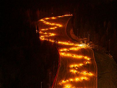 Night view of Monte Santo di Lussari, Italy, with illuminated buildings and a snowy slope. The Di Prampero slope in Camporosso welcomed the new year with the longest torchlight procession in the entire Alpine arc. Night view of Monte Santo di Lussari, Italy, with illuminated buildings and a snowy slope. The Di Prampero slope in Camporosso welcomed the new year with the longest torchlight procession in the entire Alpine arc.