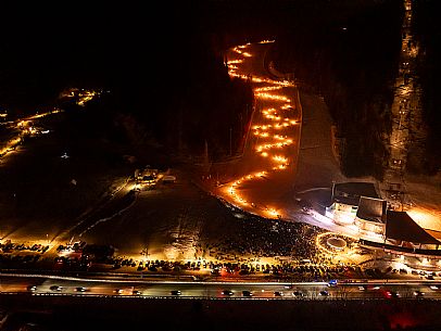 Night view of Monte Santo di Lussari, Italy, with illuminated buildings and a snowy slope. The Di Prampero slope in Camporosso welcomed the new year with the longest torchlight procession in the entire Alpine arc. Night view of Monte Santo di Lussari, Italy, with illuminated buildings and a snowy slope. The Di Prampero slope in Camporosso welcomed the new year with the longest torchlight procession in the entire Alpine arc.
