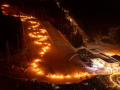 Night view of Monte Santo di Lussari, Italy, with illuminated buildings and a snowy slope. The Di Prampero slope in Camporosso welcomed the new year with the longest torchlight procession in the entire Alpine arc. Night view of Monte Santo di Lussari, Italy, with illuminated buildings and a snowy slope. The Di Prampero slope in Camporosso welcomed the new year with the longest torchlight procession in the entire Alpine arc.