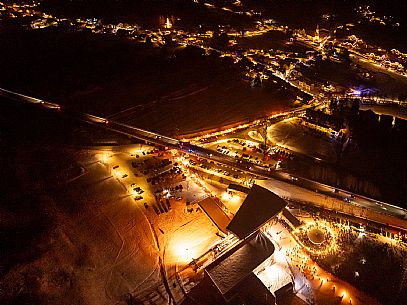 Night view of Monte Santo di Lussari, Italy, with illuminated buildings and a snowy slope. The Di Prampero slope in Camporosso welcomed the new year with the longest torchlight procession in the entire Alpine arc. Night view of Monte Santo di Lussari, Italy, with illuminated buildings and a snowy slope. The Di Prampero slope in Camporosso welcomed the new year with the longest torchlight procession in the entire Alpine arc.