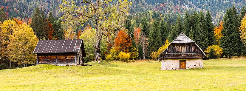 The meadows of Val Bartolo. Here you can immerse yourself in greenery, an expanse of meadows dotted with traditional mountain huts, characterised by wood and sloping roofs with balconies adorned with flowers. Landscapes and trekking in autumn.