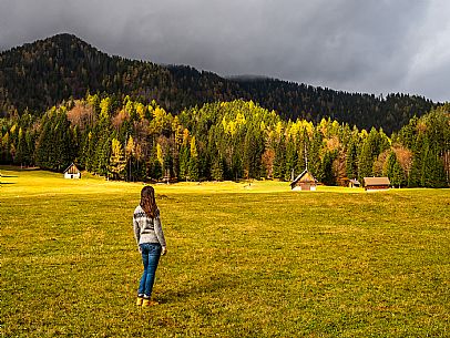 The meadows of Val Bartolo. Here you can immerse yourself in greenery, an expanse of meadows dotted with traditional mountain huts, characterised by wood and sloping roofs with balconies adorned with flowers. Landscapes and trekking in autumn.