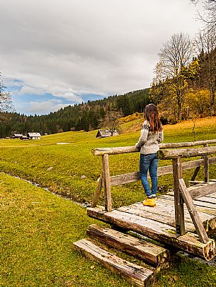 The meadows of Val Bartolo. Here you can immerse yourself in greenery, an expanse of meadows dotted with traditional mountain huts, characterised by wood and sloping roofs with balconies adorned with flowers. Landscapes and trekking in autumn.
