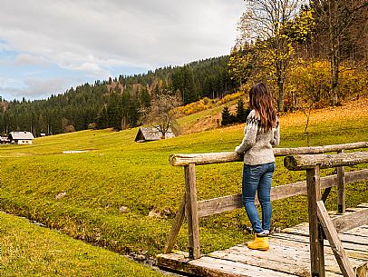 The meadows of Val Bartolo. Here you can immerse yourself in greenery, an expanse of meadows dotted with traditional mountain huts, characterised by wood and sloping roofs with balconies adorned with flowers. Landscapes and trekking in autumn.