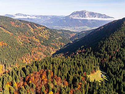 The meadows of Val Bartolo. Here you can immerse yourself in greenery, an expanse of meadows dotted with traditional mountain huts, characterised by wood and sloping roofs with balconies adorned with flowers. Landscapes and trekking in autumn.