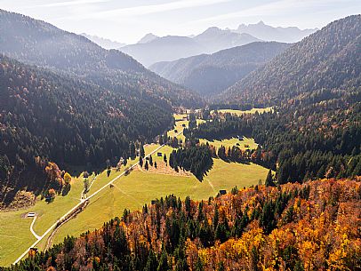The meadows of Val Bartolo. Here you can immerse yourself in greenery, an expanse of meadows dotted with traditional mountain huts, characterised by wood and sloping roofs with balconies adorned with flowers. Landscapes and trekking in autumn.