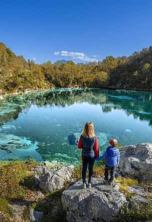 Lake Cornino, a small body of water of glacial origin located in the hilly area of Forgaria, in Friuli-Venezia Giulia. Approximately 140 metres long and 8 metres deep, it has an isolated water basin that receives continuous water exchange from underground aquifers, which allow it to maintain a constant temperature between 8 and 11 °C throughout the year, as well as a characteristic clarity, even in autumn as in these images. The lake is surrounded by a still well-preserved natural environment, and is protected as a Regional Nature Reserve, with guided trails offered for families and groups.