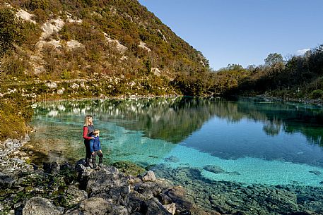 Lake Cornino, a small body of water of glacial origin located in the hilly area of Forgaria, in Friuli-Venezia Giulia. Approximately 140 metres long and 8 metres deep, it has an isolated water basin that receives continuous water exchange from underground aquifers, which allow it to maintain a constant temperature between 8 and 11 °C throughout the year, as well as a characteristic clarity, even in autumn as in these images. The lake is surrounded by a still well-preserved natural environment, and is protected as a Regional Nature Reserve, with guided trails offered for families and groups.