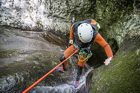 Canyoning in Rio Pielungo, Val d’Arzino Friuli Venezia Giulia, Italy. Participants navigate a spectacular canyon system carved into limestone and dolomite rock, progressing through narrow gorges, natural pools, waterfalls and rope descents under the supervision of the guide. The Rio Pielungo is considered one of the most scenic canyoning routes in the region, combining technical progression, geological interest and a uniquely wild atmosphere shaped by water and time.  [IT] Canyoning nel Rio Pielungo, Val d’Arzino (Friuli Venezia Giulia, Italia). I partecipanti attraversano uno spettacolare sistema di canyon scavato nelle rocce calcaree e dolomitiche, avanzando tra strette gole, pozze naturali, cascate e calate su corda sotto la supervisione di una Guida certificata. Il Rio Pielungo è considerato uno dei percorsi di canyoning più suggestivi della regione, grazie alla combinazione di progressione tecnica, interesse geologico e un’atmosfera autenticamente selvaggia modellata dall’acqua e dal tempo.