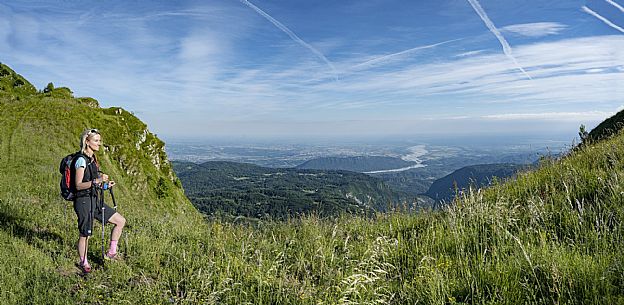 Mount Cuar, Friuli Venezia Giulia, Italy. Young hiker along the summit ridge connecting Cuel dai Poz to the summit of Mount Cuar, with a panoramic view overlooking the Friulian Plain and the surrounding landscape. [IT] Monte Cuar, Friuli Venezia Giulia, Italia. Giovane escursionista lungo la cresta sommitale che collega il Cuel dai Poz alla vetta del Monte Cuar, con vista panoramica sulla pianura friulana e sul paesaggio circostante.