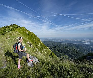 Mount Cuar, Friuli Venezia Giulia, Italy. Young hiker along the summit ridge connecting Cuel dai Poz to the summit of Mount Cuar, with a panoramic view overlooking the Friulian Plain and the surrounding landscape. [IT] Monte Cuar, Friuli Venezia Giulia, Italia. Giovane escursionista lungo la cresta sommitale che collega il Cuel dai Poz alla vetta del Monte Cuar, con vista panoramica sulla pianura friulana e sul paesaggio circostante.