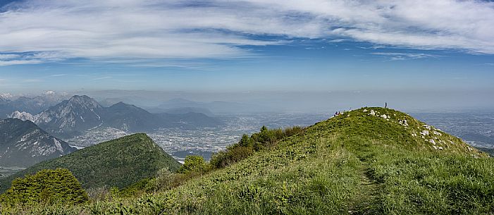 Mount Cuar, Friuli Venezia Giulia, Italy. Young hiker along the summit ridge connecting Cuel dai Poz to the summit of Mount Cuar, with a panoramic view overlooking the Friulian Plain and the surrounding landscape. [IT] Monte Cuar, Friuli Venezia Giulia, Italia. Giovane escursionista lungo la cresta sommitale che collega il Cuel dai Poz alla vetta del Monte Cuar, con vista panoramica sulla pianura friulana e sul paesaggio circostante.