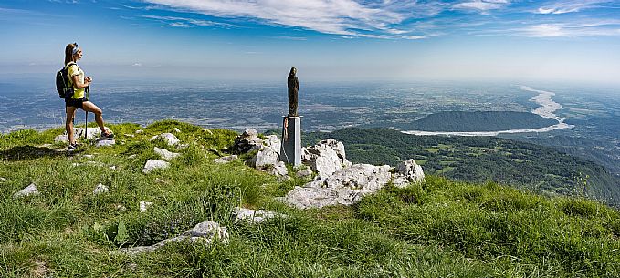 Mount Cuar, Friuli Venezia Giulia, Italy. Young hiker along the summit ridge connecting Cuel dai Poz to the summit of Mount Cuar, with a panoramic view overlooking the Friulian Plain and the surrounding landscape. [IT] Monte Cuar, Friuli Venezia Giulia, Italia. Giovane escursionista lungo la cresta sommitale che collega il Cuel dai Poz alla vetta del Monte Cuar, con vista panoramica sulla pianura friulana e sul paesaggio circostante.