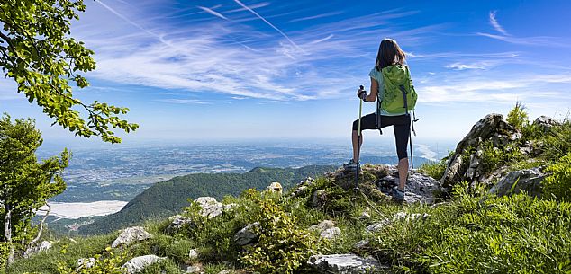 Mount Cuar, Friuli Venezia Giulia, Italy. Young hiker along the summit ridge connecting Cuel dai Poz to the summit of Mount Cuar, with a panoramic view overlooking the Friulian Plain and the surrounding landscape. [IT] Monte Cuar, Friuli Venezia Giulia, Italia. Giovane escursionista lungo la cresta sommitale che collega il Cuel dai Poz alla vetta del Monte Cuar, con vista panoramica sulla pianura friulana e sul paesaggio circostante.