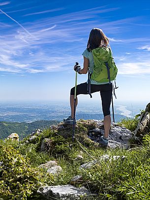 Mount Cuar, Friuli Venezia Giulia, Italy. Young hiker along the summit ridge connecting Cuel dai Poz to the summit of Mount Cuar, with a panoramic view overlooking the Friulian Plain and the surrounding landscape. [IT] Monte Cuar, Friuli Venezia Giulia, Italia. Giovane escursionista lungo la cresta sommitale che collega il Cuel dai Poz alla vetta del Monte Cuar, con vista panoramica sulla pianura friulana e sul paesaggio circostante.