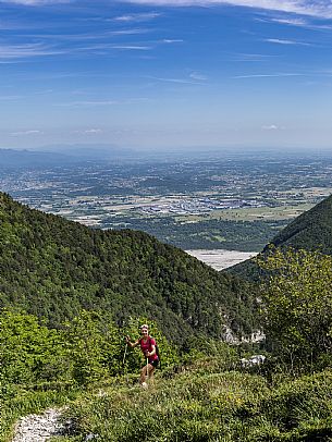 Mount Cuar, Friuli Venezia Giulia, Italy. Young hiker along the summit ridge connecting Cuel dai Poz to the summit of Mount Cuar, with a panoramic view overlooking the Friulian Plain and the surrounding landscape. [IT] Monte Cuar, Friuli Venezia Giulia, Italia. Giovane escursionista lungo la cresta sommitale che collega il Cuel dai Poz alla vetta del Monte Cuar, con vista panoramica sulla pianura friulana e sul paesaggio circostante.