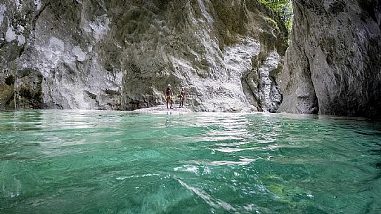 Canyoning in Rio Pielungo, Val d’Arzino Friuli Venezia Giulia, Italy. Participants navigate a spectacular canyon system carved into limestone and dolomite rock, progressing through narrow gorges, natural pools, waterfalls and rope descents under the supervision of the guide. The Rio Pielungo is considered one of the most scenic canyoning routes in the region, combining technical progression, geological interest and a uniquely wild atmosphere shaped by water and time.  [IT] Canyoning nel Rio Pielungo, Val d’Arzino (Friuli Venezia Giulia, Italia). I partecipanti attraversano uno spettacolare sistema di canyon scavato nelle rocce calcaree e dolomitiche, avanzando tra strette gole, pozze naturali, cascate e calate su corda sotto la supervisione di una Guida certificata. Il Rio Pielungo è considerato uno dei percorsi di canyoning più suggestivi della regione, grazie alla combinazione di progressione tecnica, interesse geologico e un’atmosfera autenticamente selvaggia modellata dall’acqua e dal tempo.